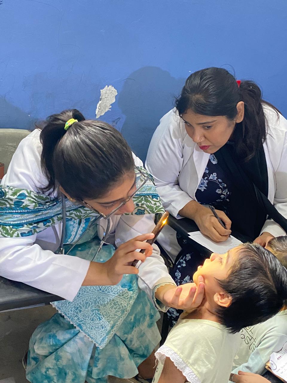 Doctors treating a child at a free medical camp
